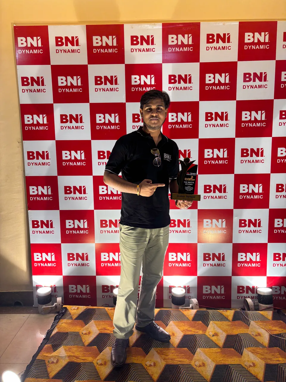 Roshan Burnwal holding a plaque in front of a BNI Dynamic backdrop.