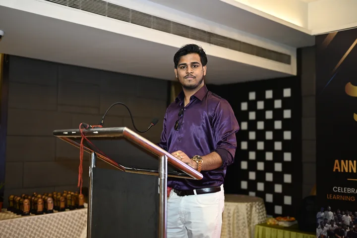 Roshan Burnwal speaking at a lectern during an indoor event.